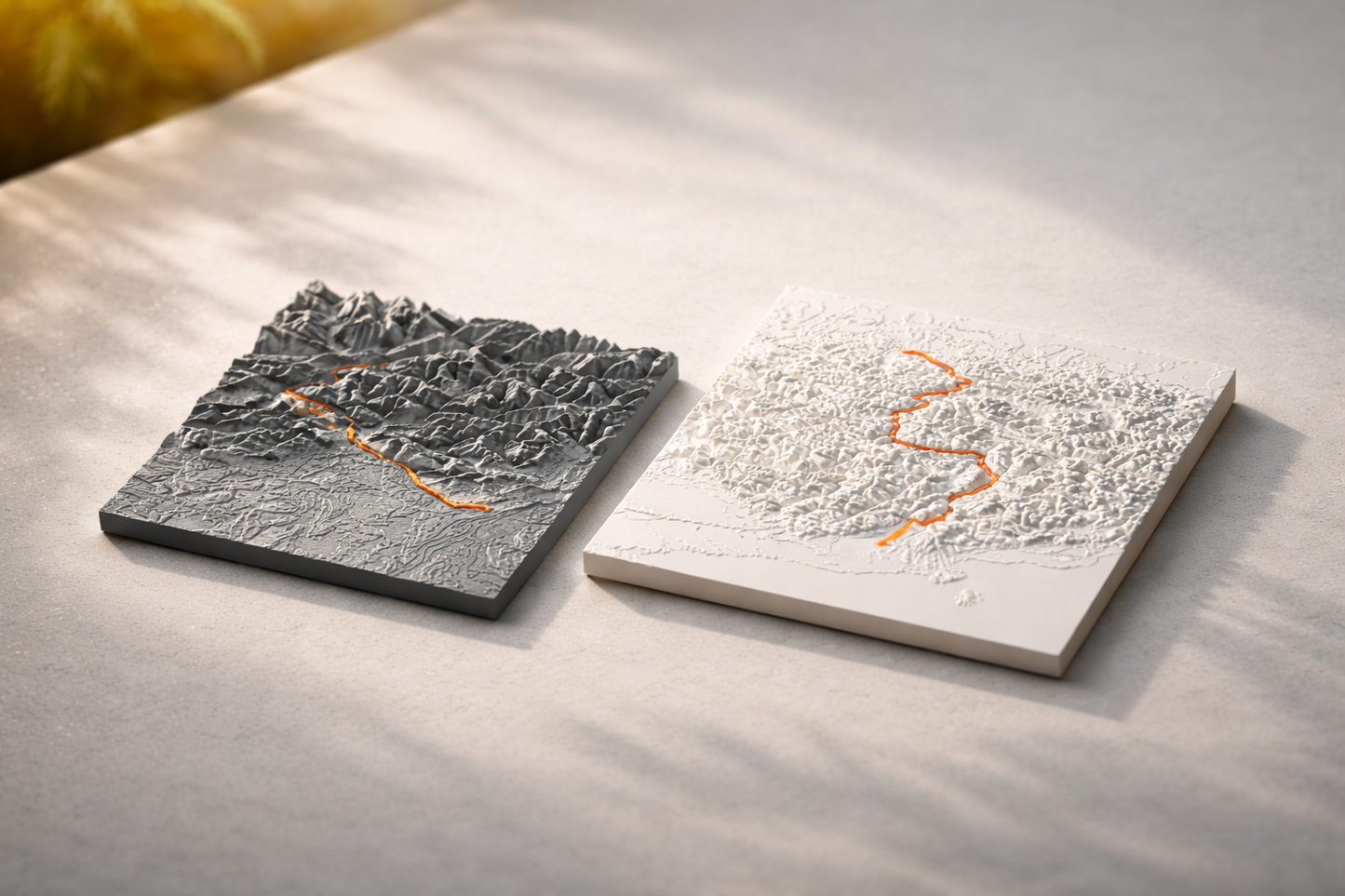 Zwei Quadratische 3D-Terrain-Modelle in Schwarz und Weiß mit Strava-Route in Orange